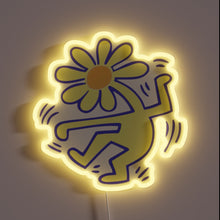 Charger l'image dans la galerie, Neon sign of a dancing figure with a daisy flower head and yellow glow.