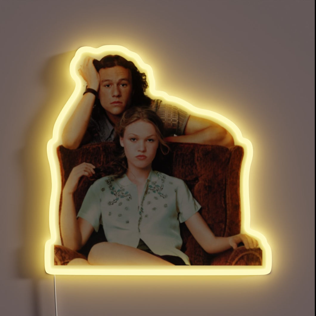 This neon sign features a scene from the 1999 teen romantic comedy *10 Things I Hate About You*, starring Heath Ledger and Julia Stiles. It's a modern adaptation of Shakespeare’s *The Taming of the Shrew*, and this image captures the chemistry between the lead characters, Patrick and Kat, in one of the film’s iconic promotional shots.