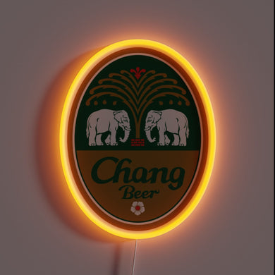 Alt text: *Neon sign in the shape of an oval Chang Beer logo with two white elephants and a glowing orange border.*