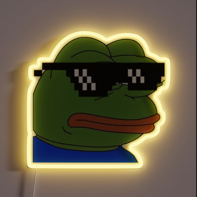 This neon sign features a stylized image of Pepe the Frog wearing pixelated “deal with it” sunglasses, surrounded by a soft yellow glow. It combines internet meme culture with retro neon aesthetics.