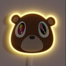Charger l&#39;image dans la galerie, Neon sign of Kanye West’s Graduation bear head with glowing yellow outline.