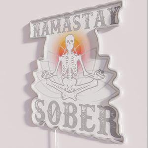 Vibrant neon sign with yoga skeleton in sobriety support humor.