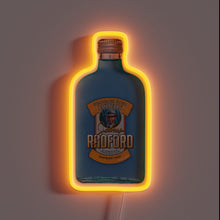 Charger l&#39;image dans la galerie, Neon sign shaped like a blue Johnny Radford Raspberry Shot bottle with orange glow.
