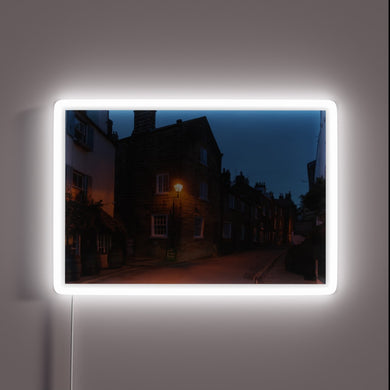 Vibrant evening glow of Robin Hood's Bay in colour-changing neon.