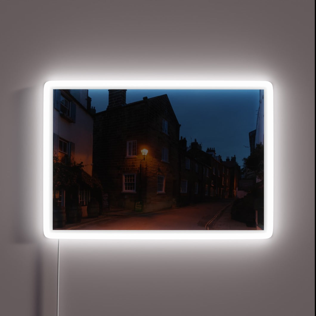 Vibrant evening glow of Robin Hood's Bay in colour-changing neon.