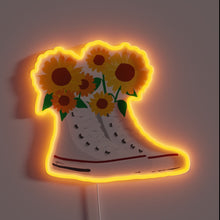 Charger l&#39;image dans la galerie, That image brings a perfect mix of retro and nature — classic high-top Chucks overflowing with sunflowers, all outlined in a warm orange neon. 🌻🔥 It gives off a strong indie-artsy vibe, great for a cozy corner or studio wall. Want a caption or product description for this one?