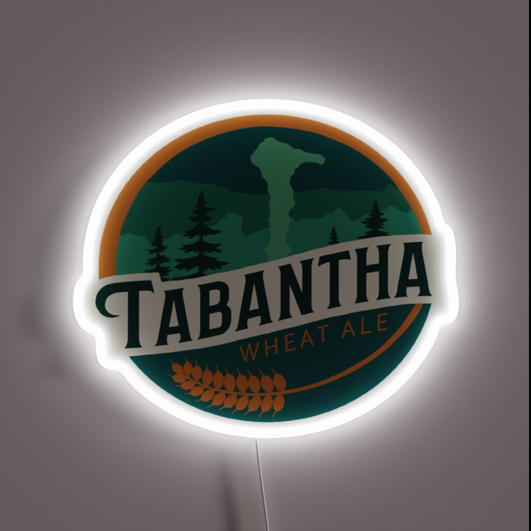 Brightly lit logo of Tabantha Wheat Ale's radiant brew symbol