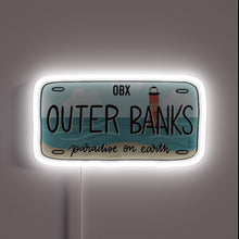 Charger l&#39;image dans la galerie, Outer Banks license plate design with beach and lighthouse, glowing white neon outline.

