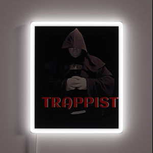 Vibrant LED light art featuring Trappist monk in radiant colors.