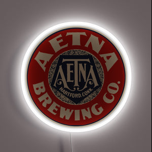 Vintage Aetna Beer advertisement with colorful neon light accents glow.
