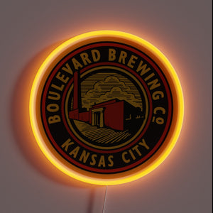Alt text: Neon-lit round sign with "Boulevard Brewing Co Kansas City" logo in black, red, and gold, featuring a factory illustration.
